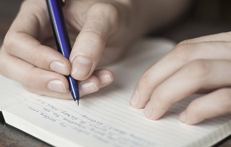 Foto de una mujer que anota los factores desencadenantes en un diario