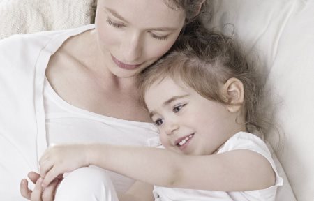 Una madre con el hijo acurrucados.