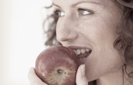 Una mujer comiendo una manzana
