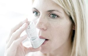 Una mujer utilizando un inhalador.