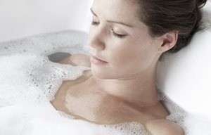 Una mujer relajándose en un baño de espuma
