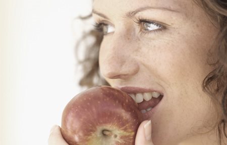 Mujer comiéndose una manzana roja