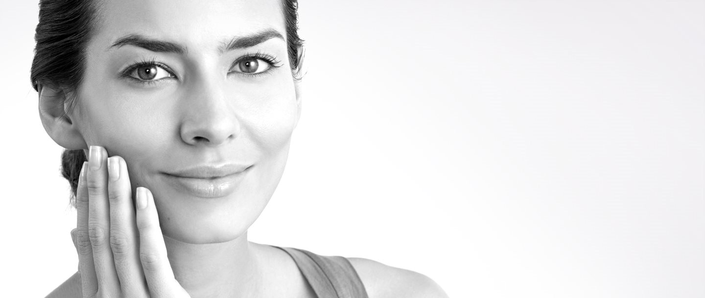 Mujer de mediana edad tocándose la mejilla derecha con la mano