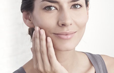 Mujer aplicándose crema en la cara