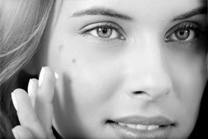 Una modelo de Eucerin utilizando un corrector de manchas para cubrir las áreas oscuras